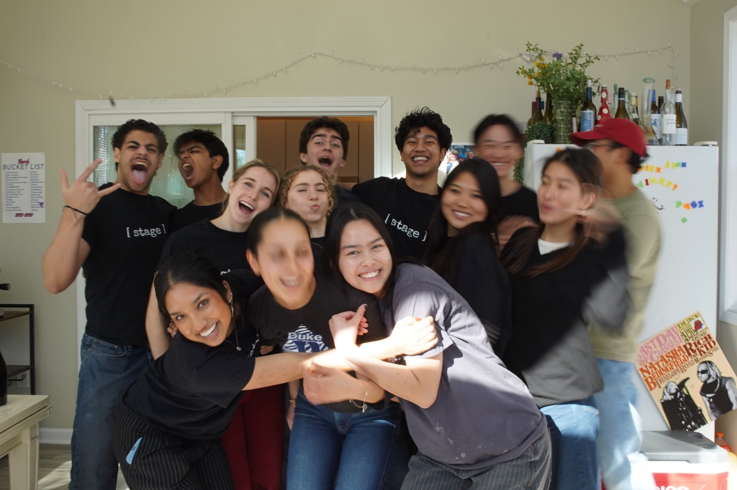 The [ stage ] team piled together in the kitchen, laughing
