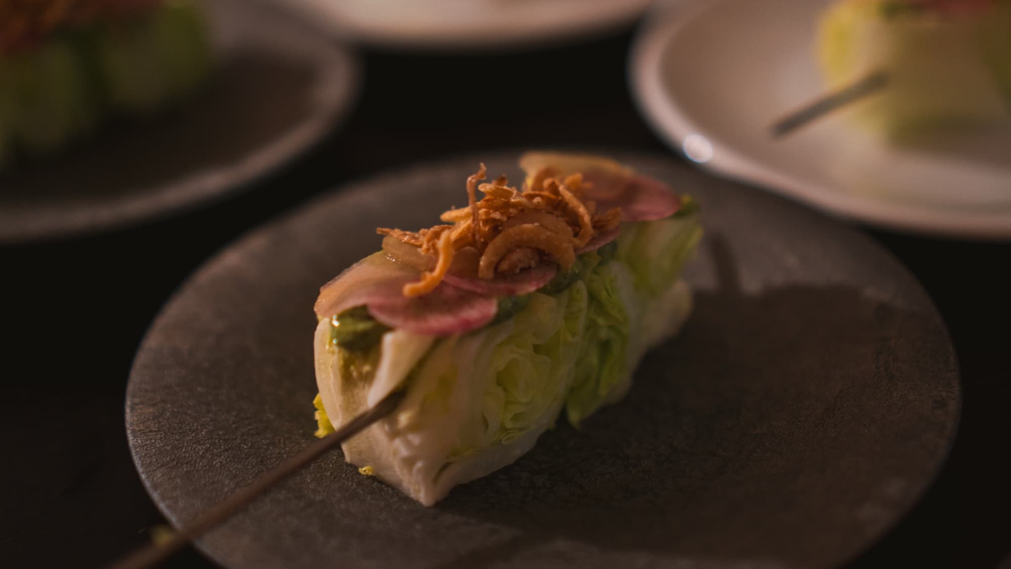 A wedge salad topped with crispy shallots