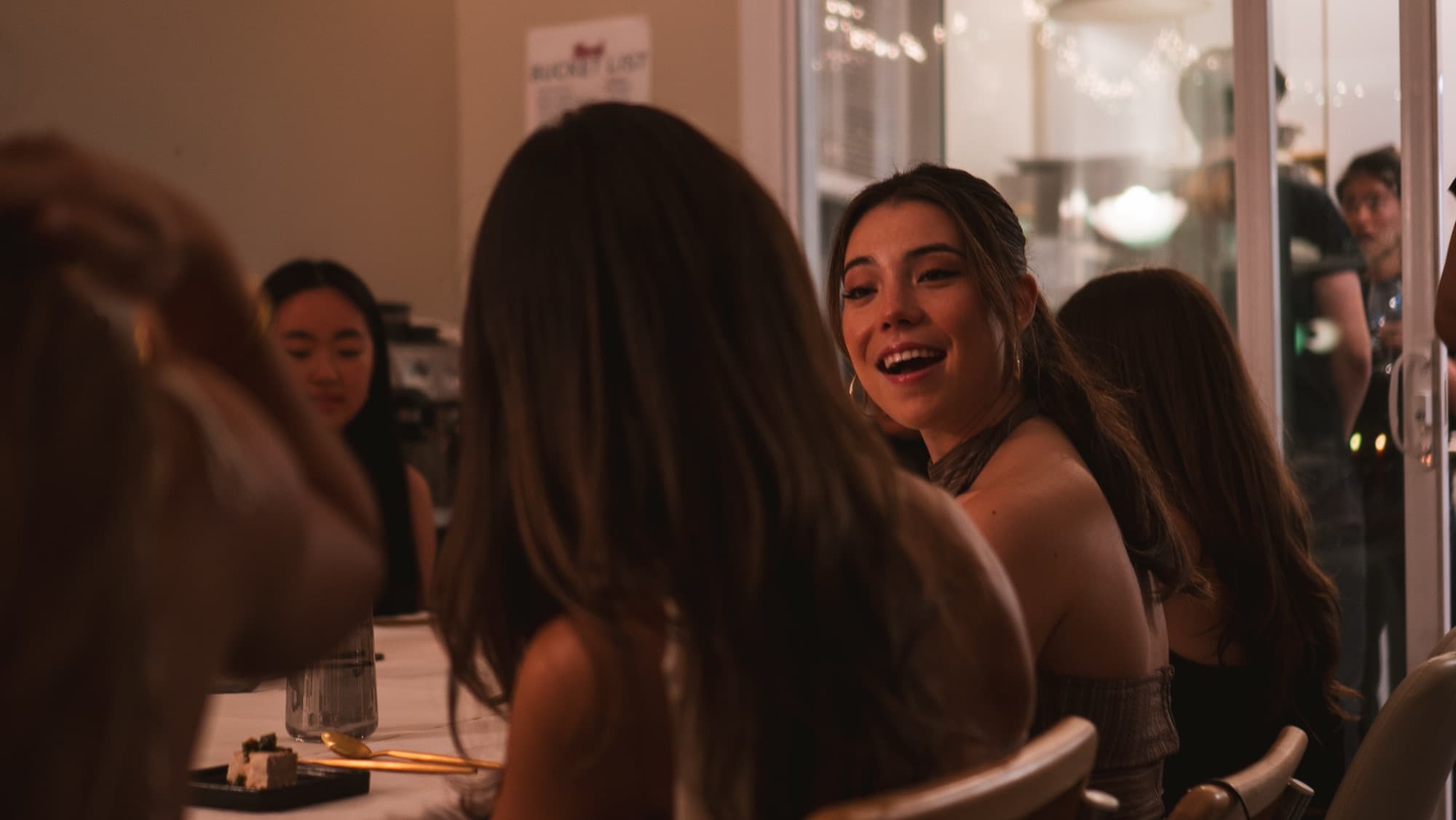 A guest laughing at the dinner table
