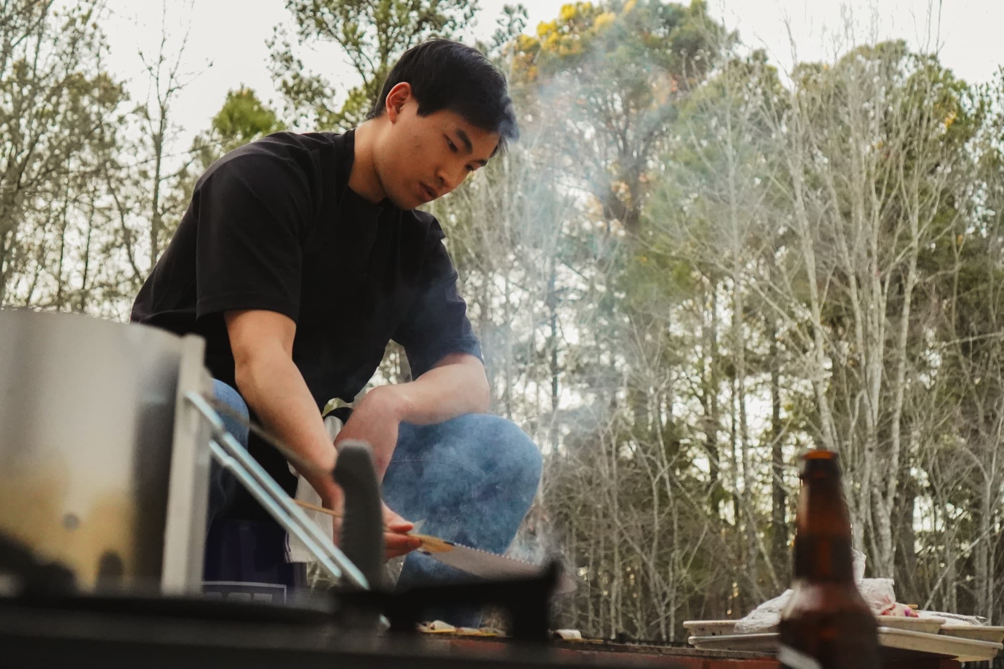 A cook working over open flame outdoors